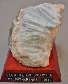Celestite on dolomite mounted on a wood base with a label