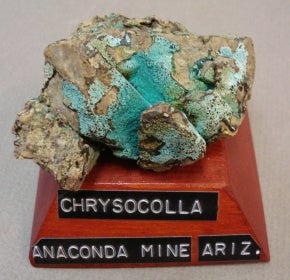 Chrysocolla mounted on a wood base with a label