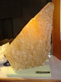 Large crystal of calcite mineral with angular shape and lighting from above
