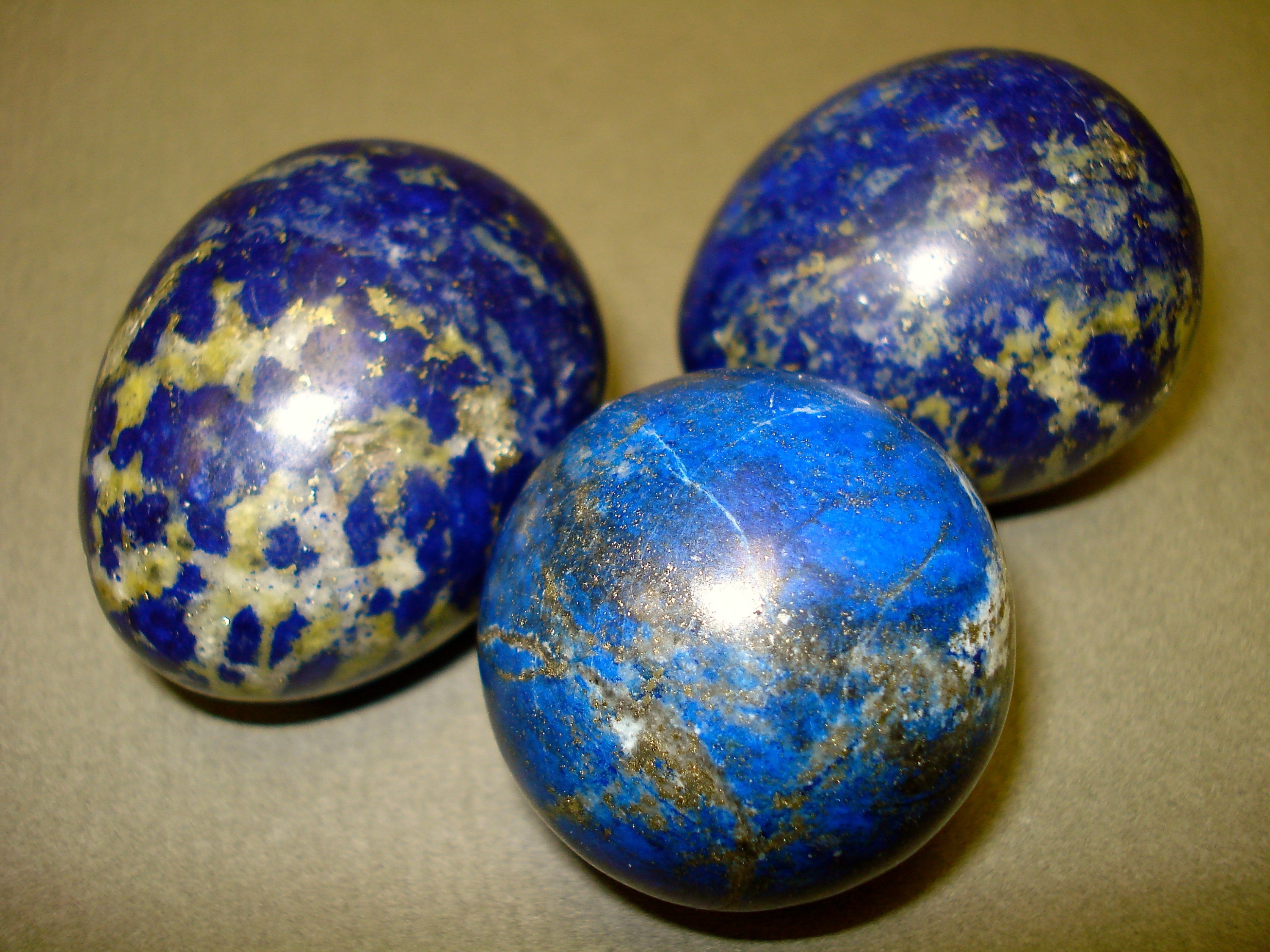 Lapis Lazuli Eggs and Sphere next to a penny for size comparison