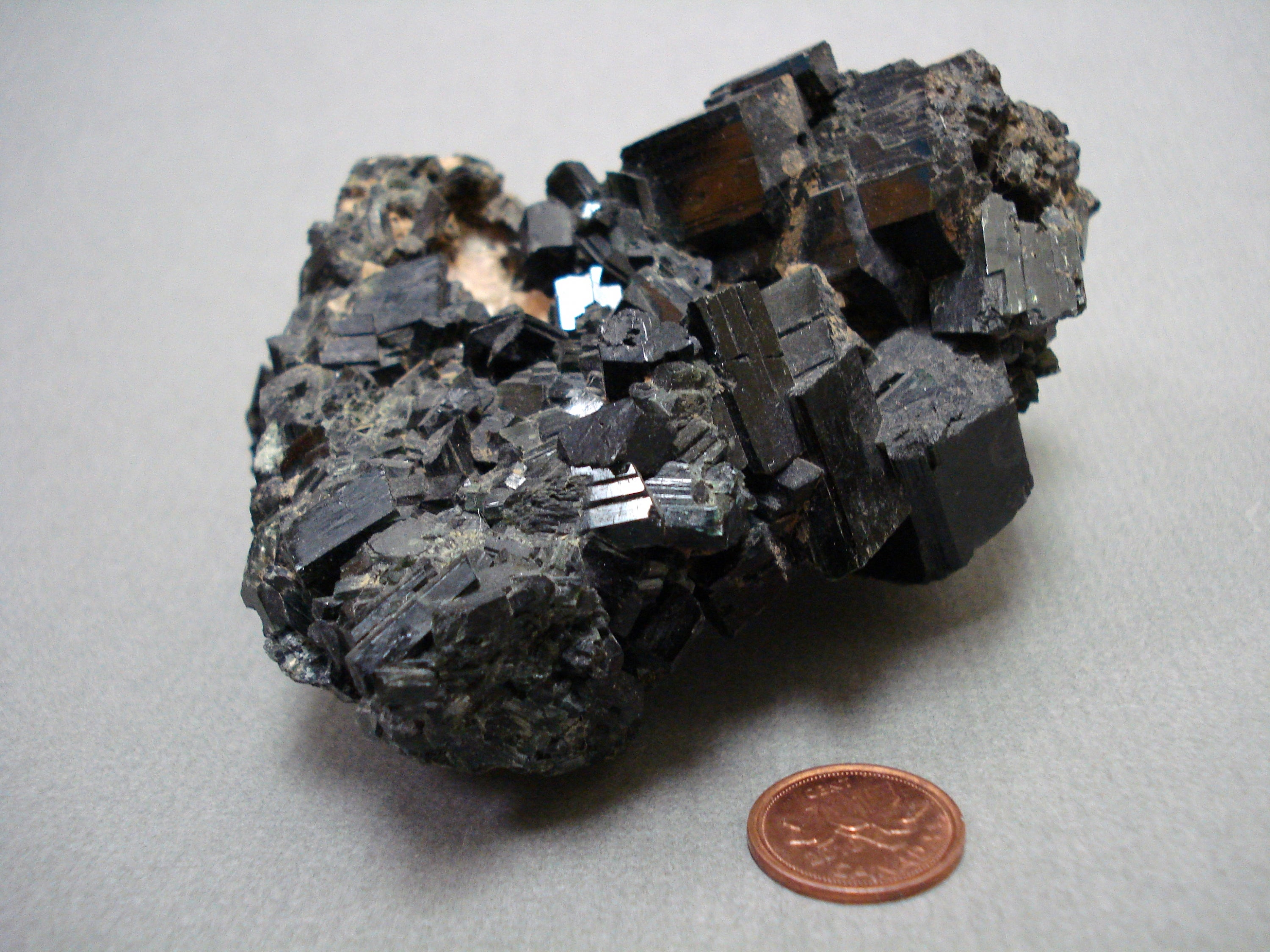 Manganite next to a penny for size comparison