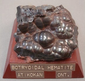 Botryoidal Hematite mounted on a wood base with a label