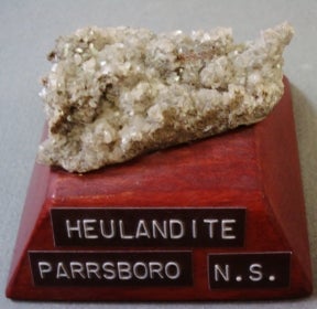 Heulandite mounted on a wood base with a label