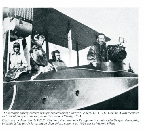 photo of four men sitting on cockpit of plane with surveying camera mounted to it