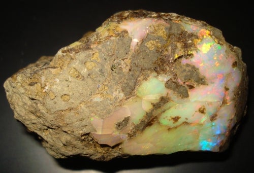 white opal with a multicolour sheen in brown rock