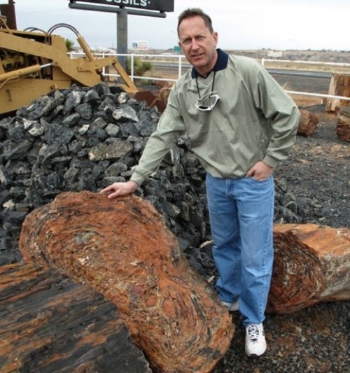jim reimer stands beside piece of wood at site of purchase