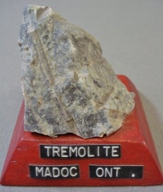Tremolite mounted on a wood base with a label