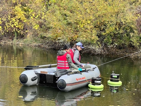 Steph Slowinski sampling on a boat in the stormwater pond.