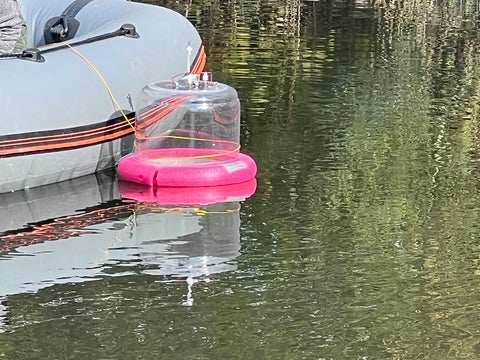 Floating chamber off a boat, sampling in the stormwater pond.