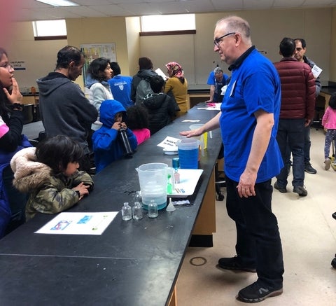 Serghei Bocaniov demonstrates an experiment to children and parents during the busy Science Open House.