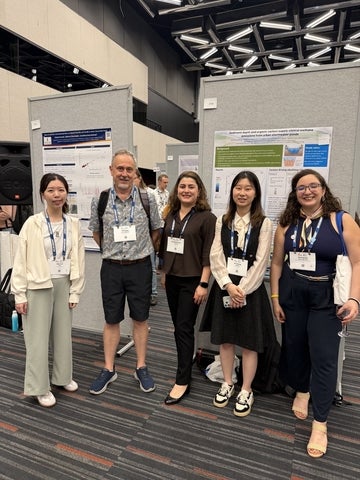 Xinchang and member by her poster at Goldschmidt