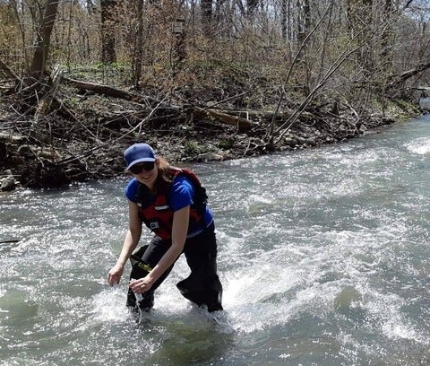 woman wearing a life jacket while standing in flowing water