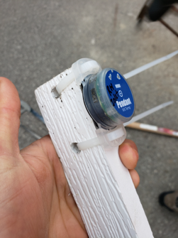 logger in blue round plastic casing attaching to white pole and held in someone's hand