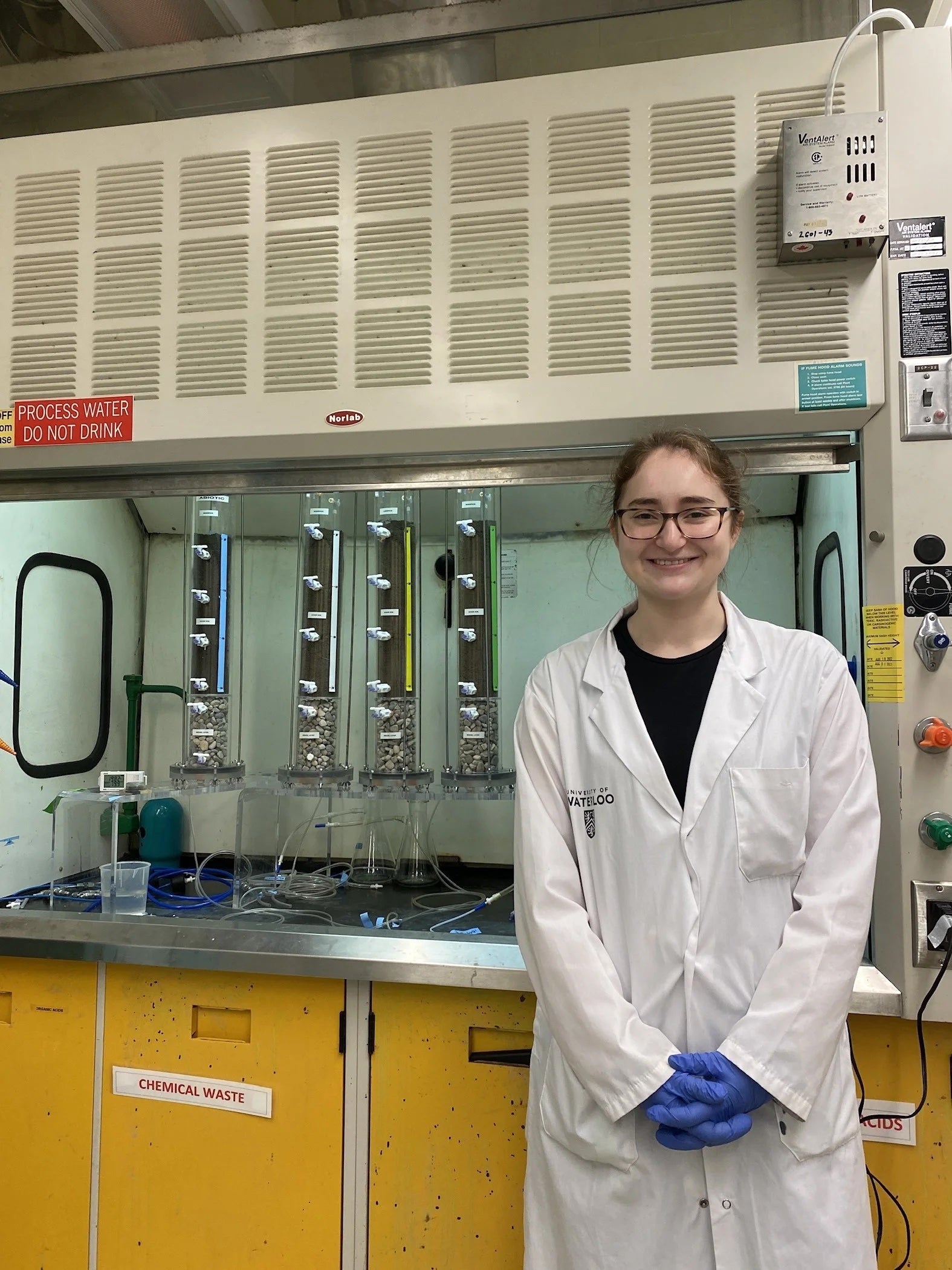 Undergraduate co-op student Melissa LeBlonc standing in the Ecohydrology Research Group lab next to her soil column experiments