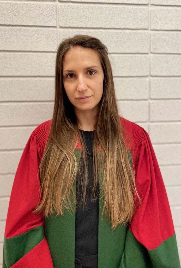 Photo of Jovana wearing red and green convocation robes