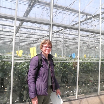 Woman standing outside a greenhouse