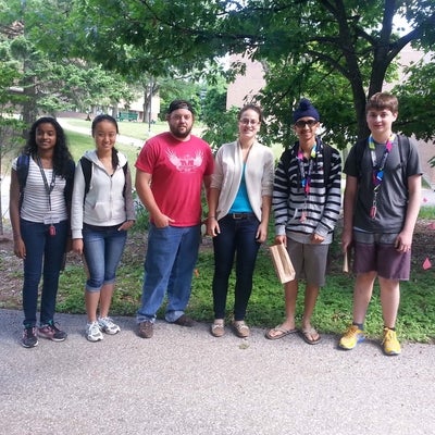 Students posing in front of naturalized garden