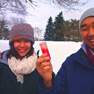 Students happy holding red liquid