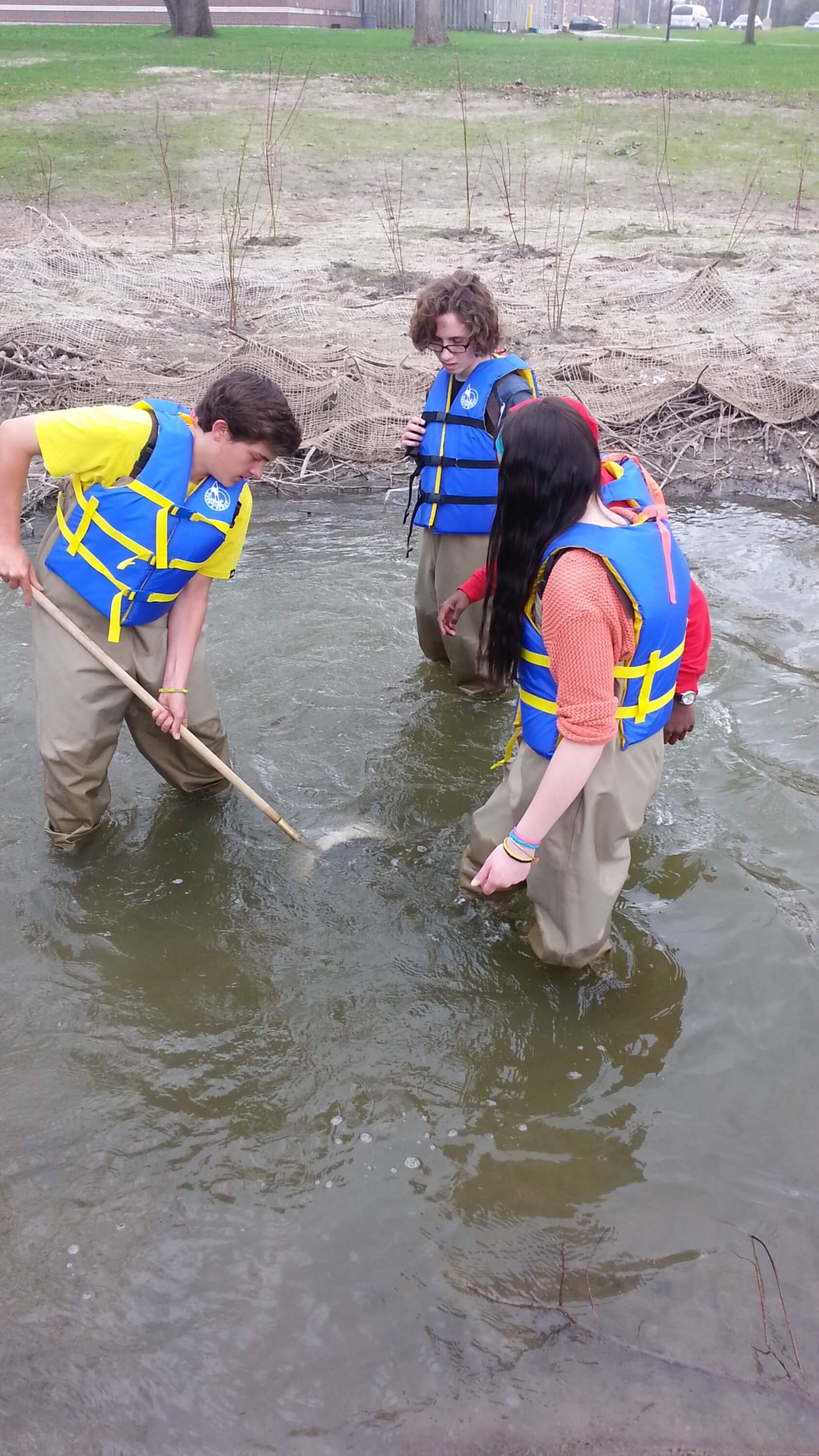 Student catching benthic invertebrates in the water