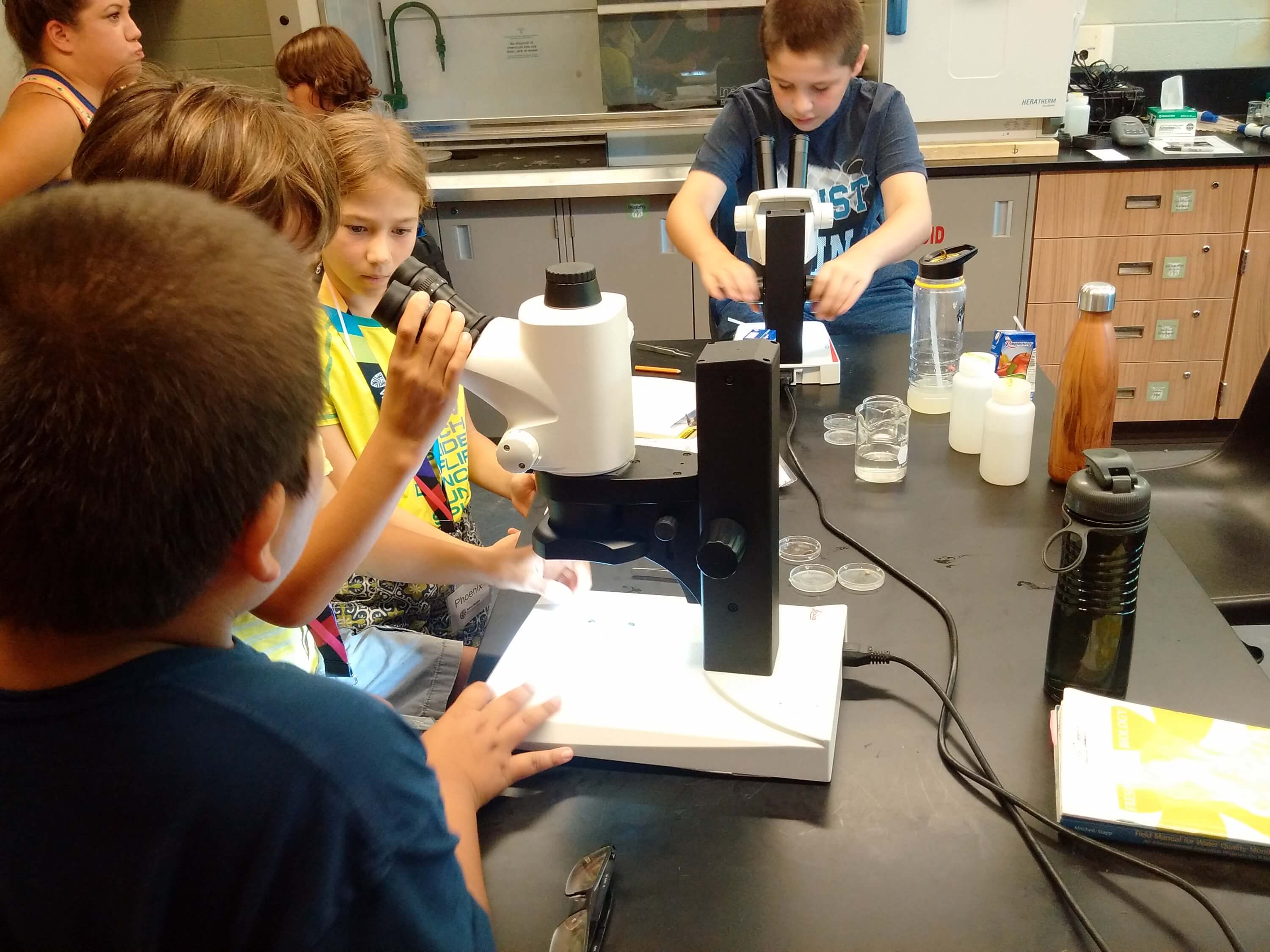 Students adjusting microscope