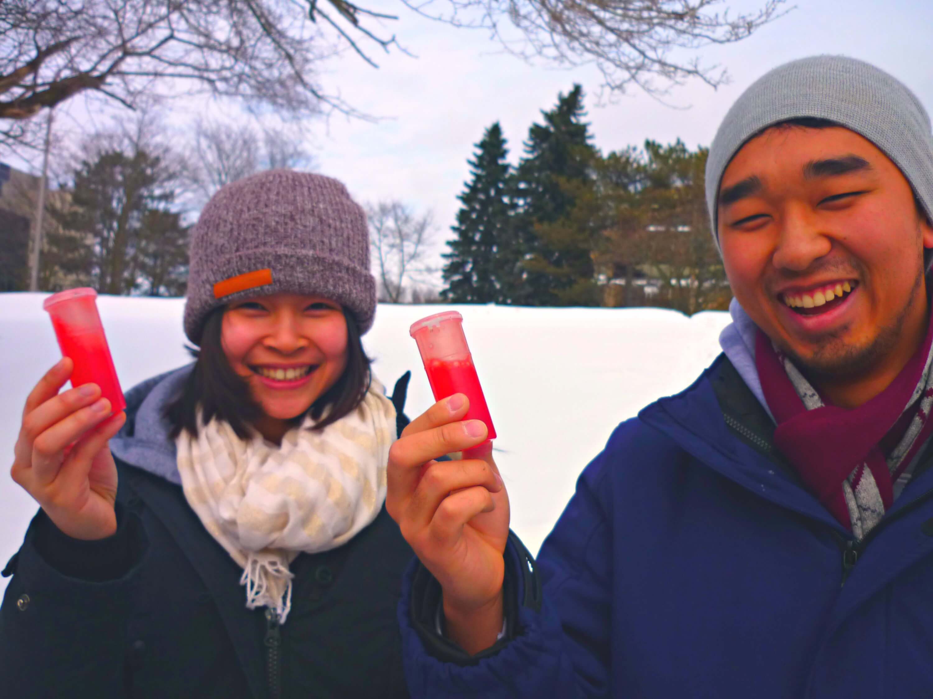 Students happy holding red liquid