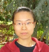 Anqi Li,  in a red shirt in front of a tree