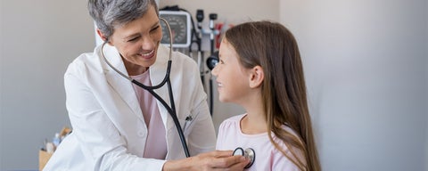 Woman doctor examining a young girl with a stethescope