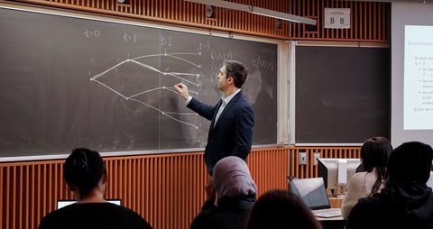 Derek teaching at board to grad class