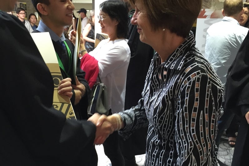 Pat Shaw shakes hands with student