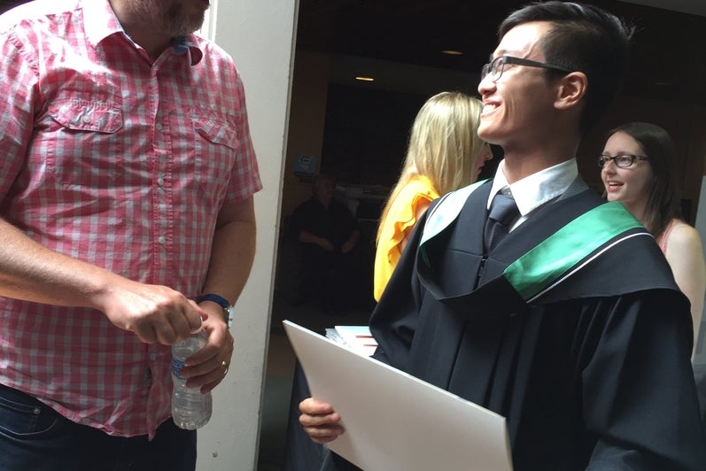 Professor Phil Curry congratulates his student Justin Ngai