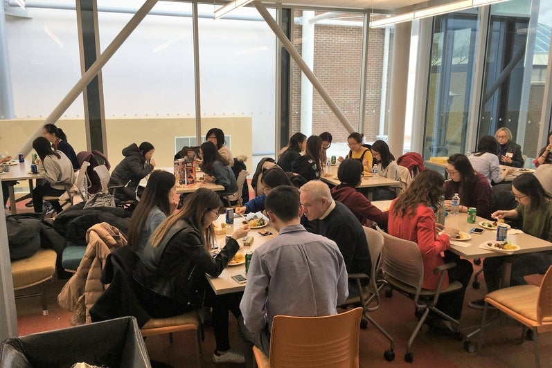 People in a room eating food at tables
