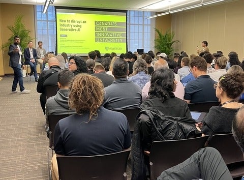 A full room of Collision participants listening to a talk on Generative AI hosted by WatSpeed