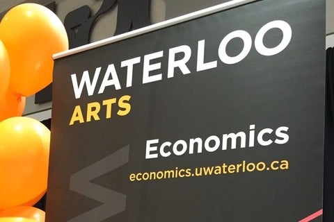 orange balloons and black banner reading Waterloo Arts, Economics