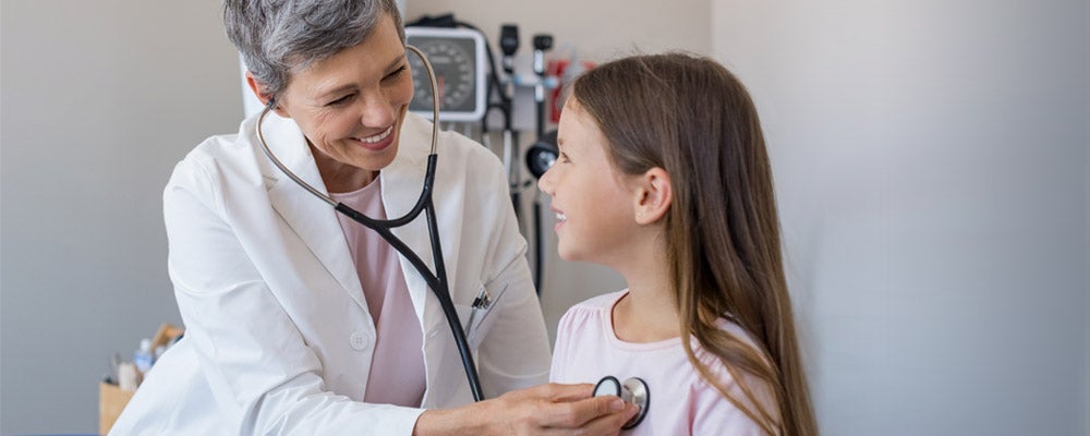 Doctor listens to the heart beat of a child