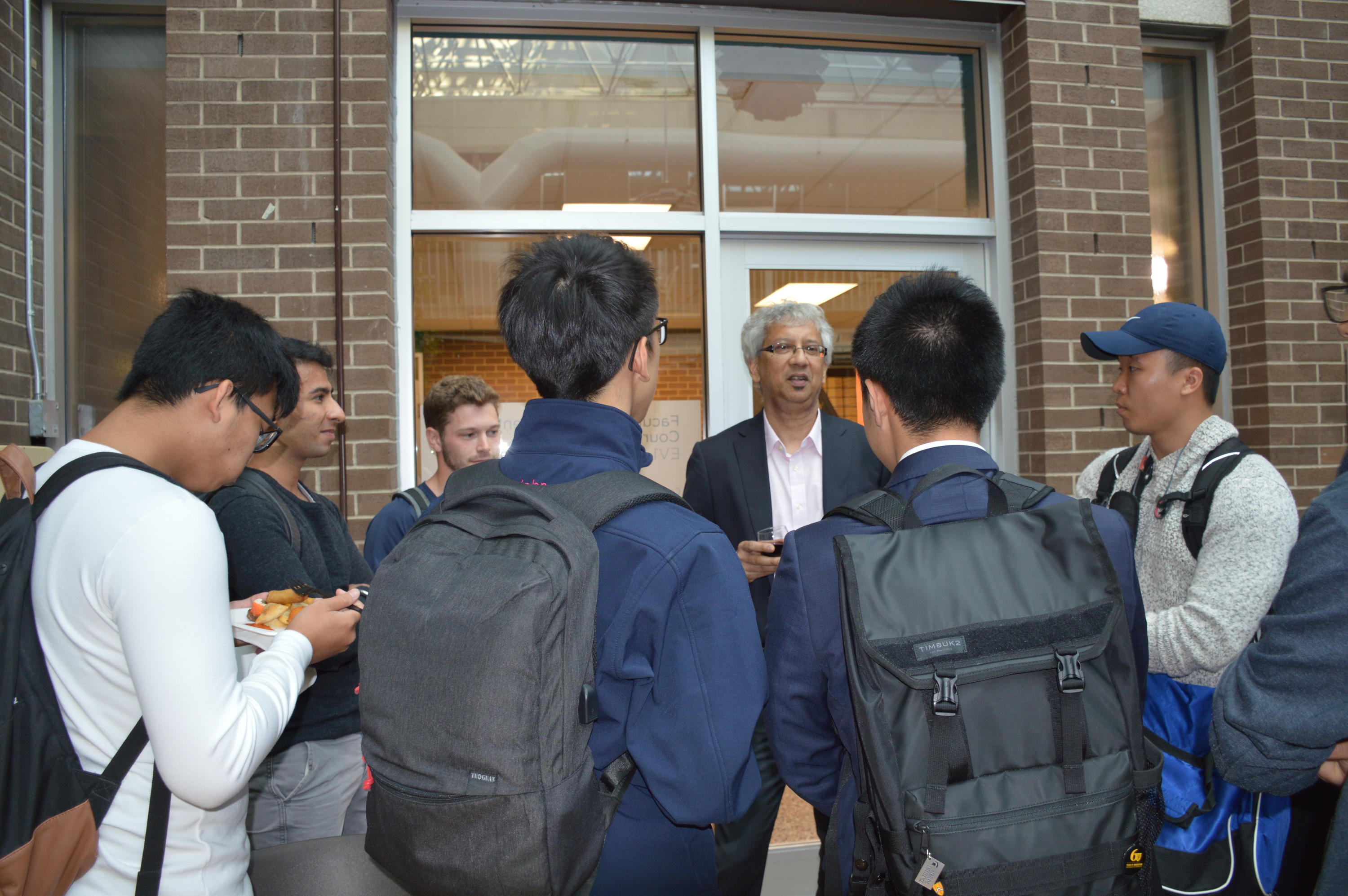 Professor Debraj Ray speaking with students at the reception. 