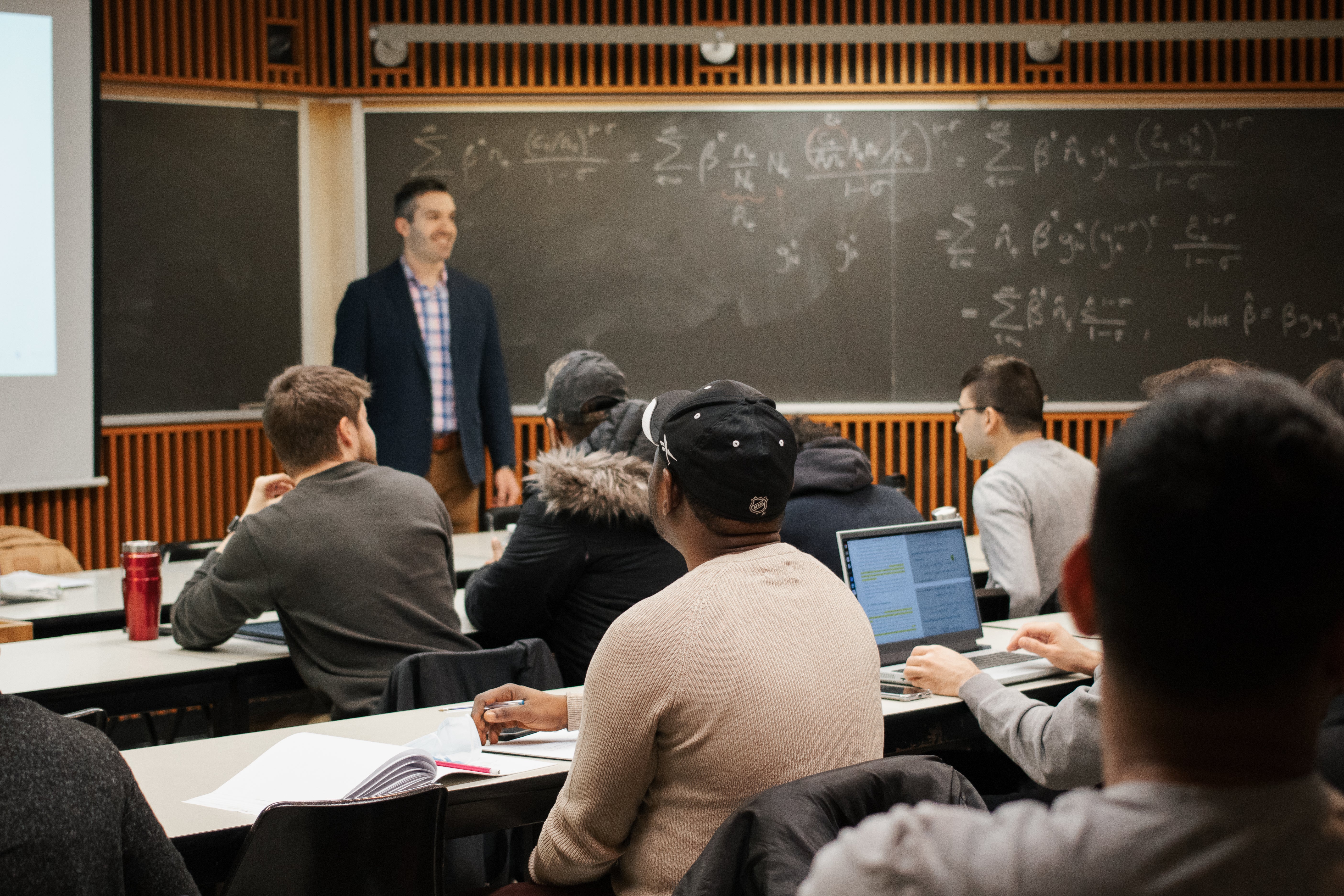 professor teaching a group of graduate students in a classroom