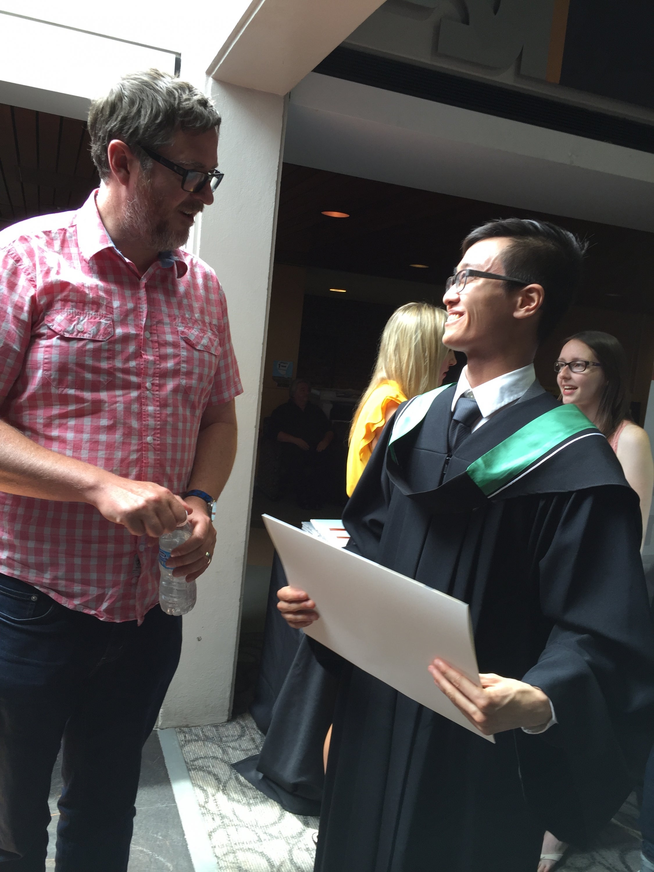 Professor Phil Curry congratulates his student Justin Ngai