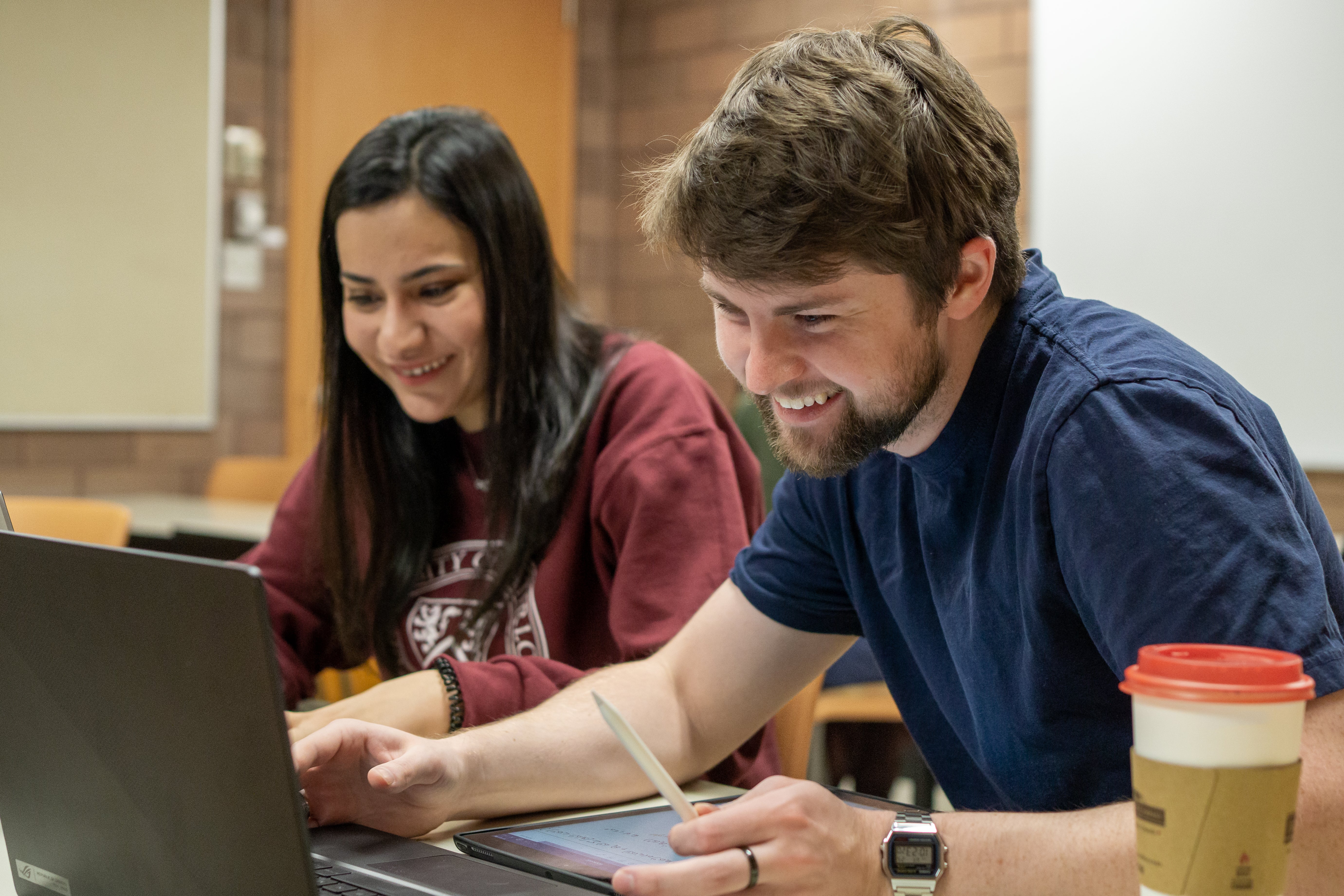 two ECON MA students sitting and smiling