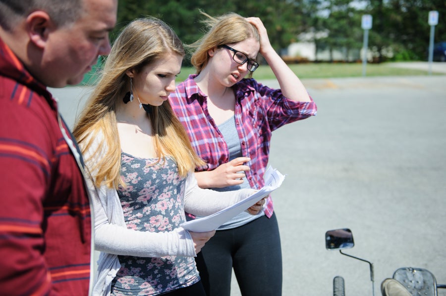 Students looking at their car