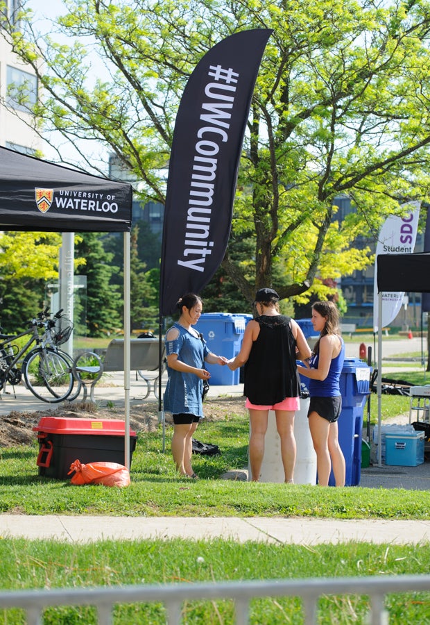 Volunteers next to a UW Community flag