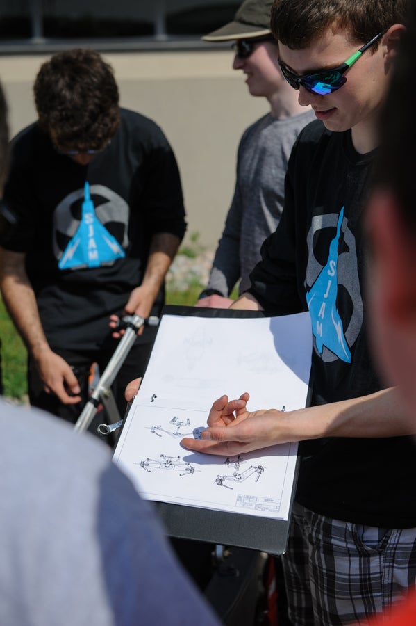 Students showing CAD drawings to a judge