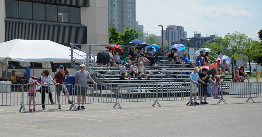 Spectators line the bleachers and railing