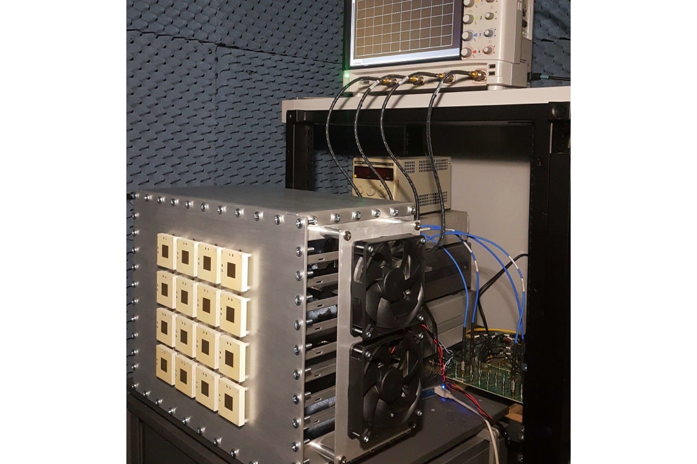 16-element phased array under test in the anechoic chamber, with an oscilloscope on the rack above