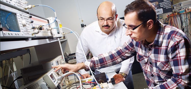 Two researchers characterizing a power device at an instrument bench in the EmRG laboratory