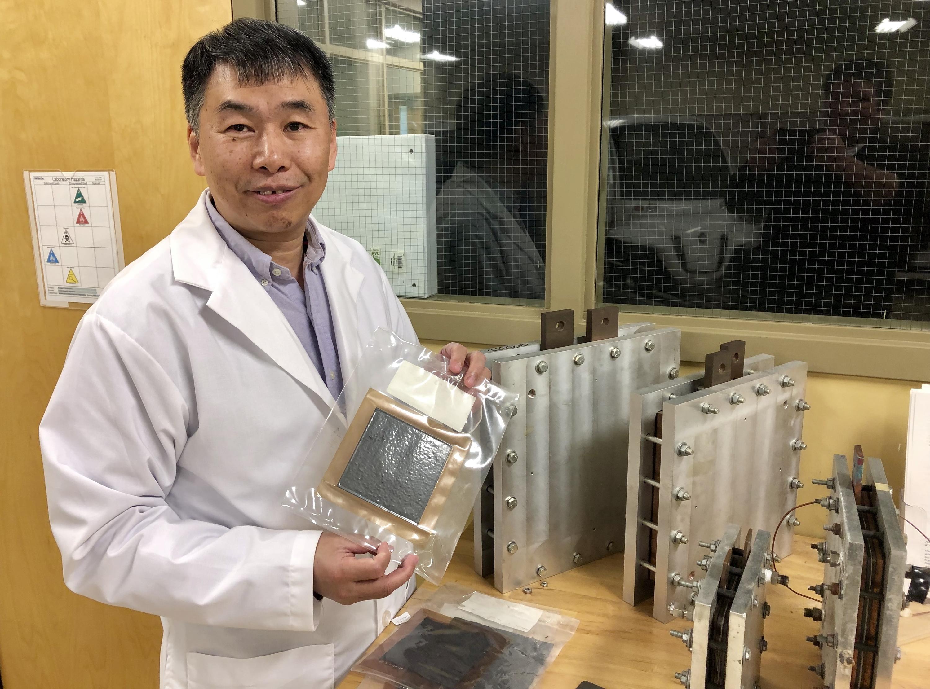 Xianguo Li displays a fuel cell in the Fuel Cell and Green Energy Lab at Waterloo Engineering.