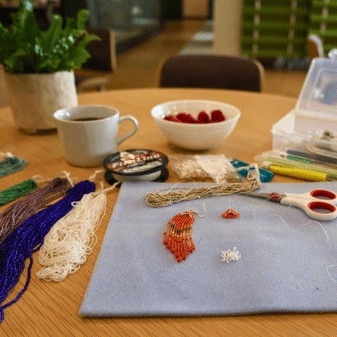 A table with beading and the tools needed for beadwork