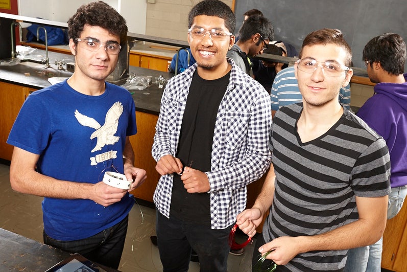 Three students pose for the camera in the lab