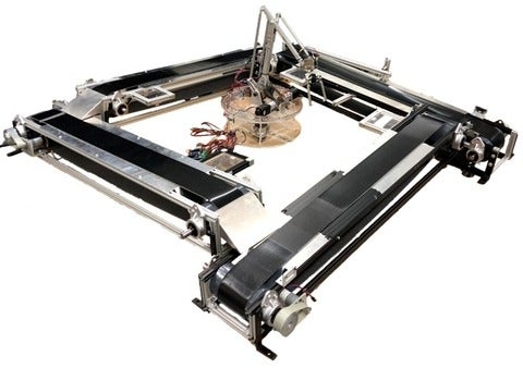 Picture of 4 belted conveyors in a square with a robotic arm in the centre.