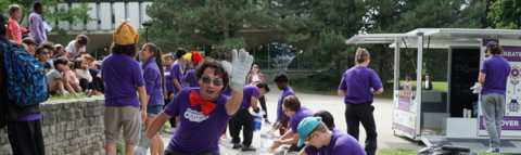 Camp Leader waving at camera holding a cooler