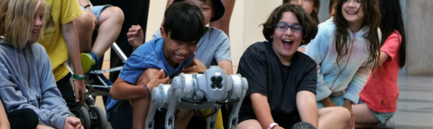 Children excitedly watching a 4-legged robot